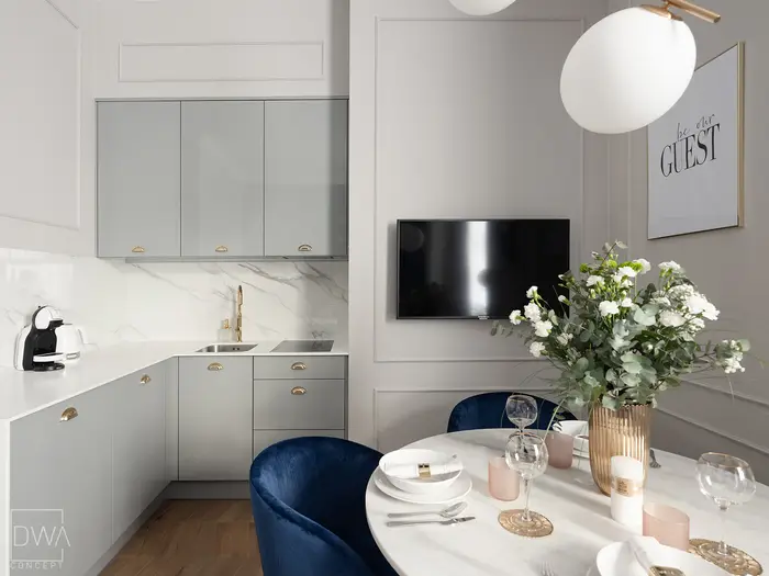 Aneks kuchenny z marmurowym panelem i złotą baterią - apartament w Krakowie
