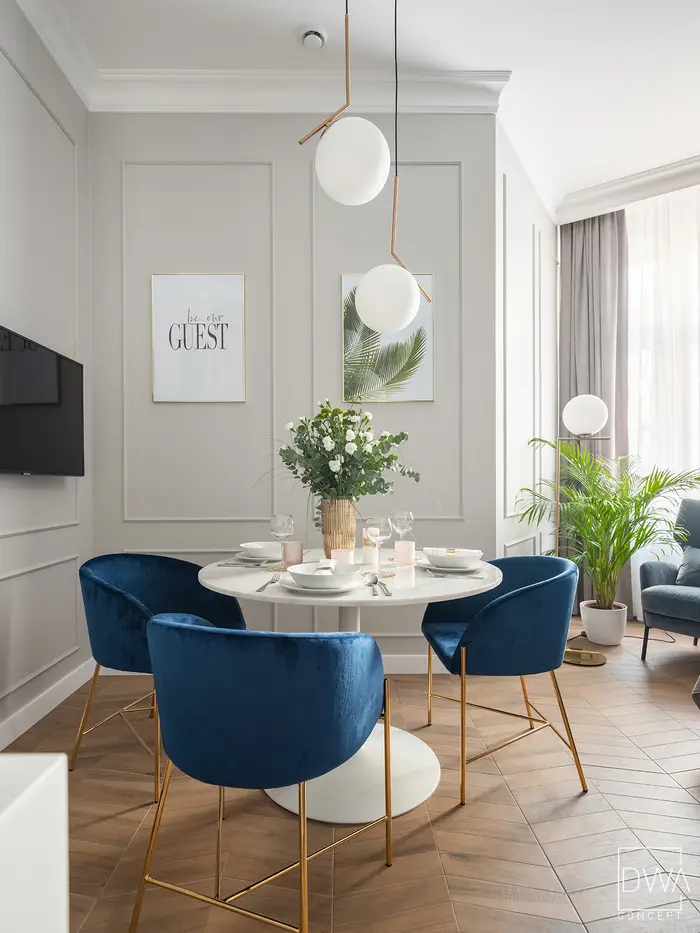 Strefa wypoczynkowa z fotelem, palmą i podłogą w jodełkę - apartament w Krakowie