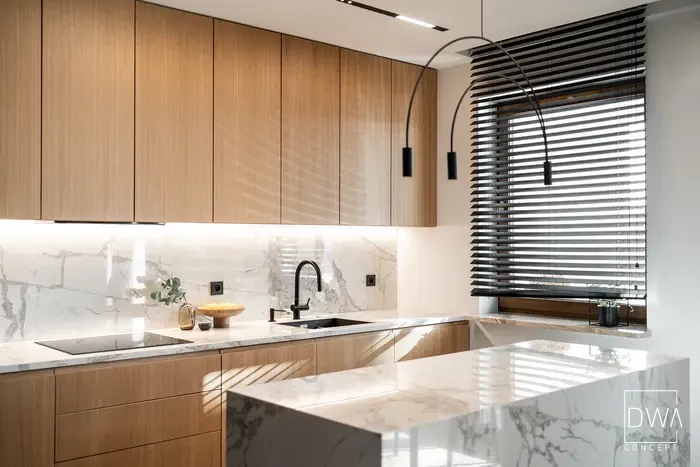 Detal kuchni z żaluzjami weneckimi i łukową lampą wiszącą - apartament w Krakowie