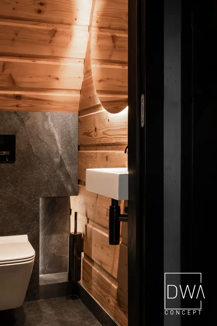 Nowoczesne WC gościnne po metamorfozie z kamienną ścianą - domek letniskowy